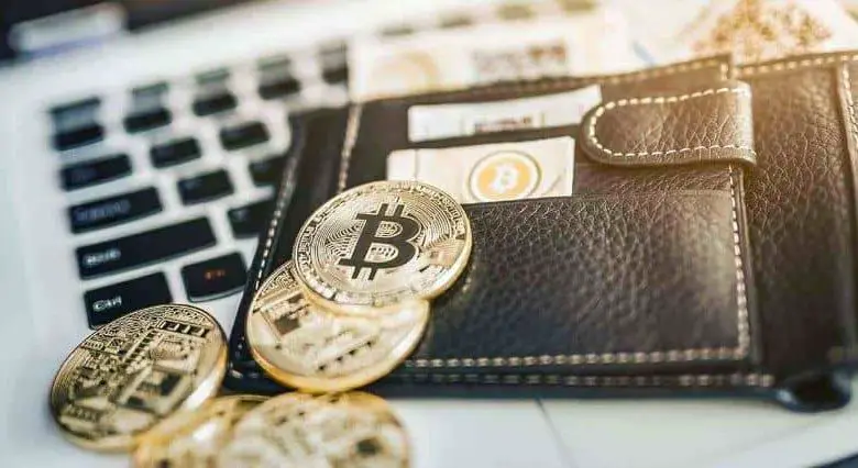 Bitcoin nel portafoglio sopra il laptop