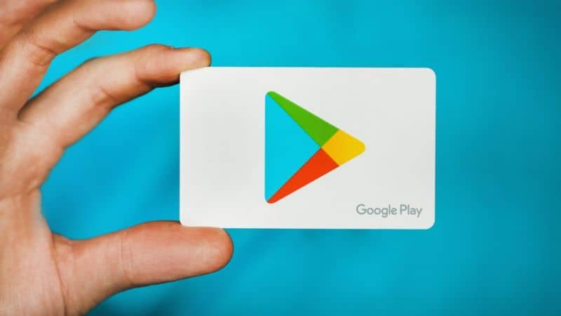 Mano che tiene la carta bianca con logo Google Play