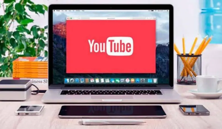 YouTub su laptop su tavolo in legno