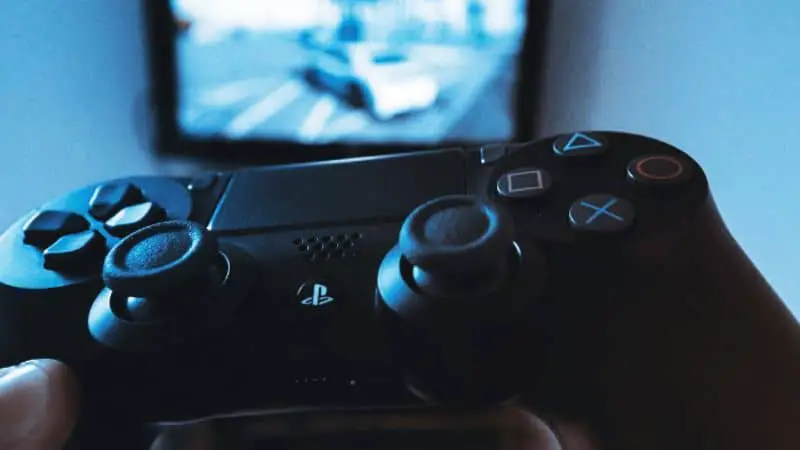 Controller PS4 con sfondo tv sfocato con carrello