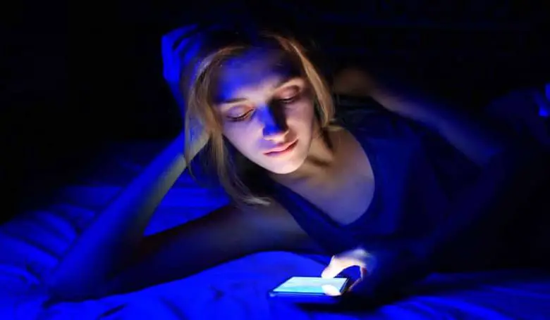Donna che guarda il suo telefono di notte