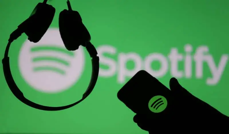 Logo Spotify Cuffie e cellulare in mano
