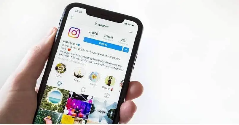 iphone mobile tenuto da una mano e guardando un feed di instagram