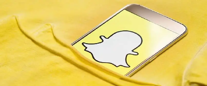 sfondo giallo evidenzia da una tasca un cellulare con il logo snapchat