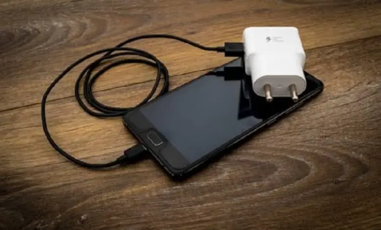 dispositivo mobile con cavo USB e adattatore bianco