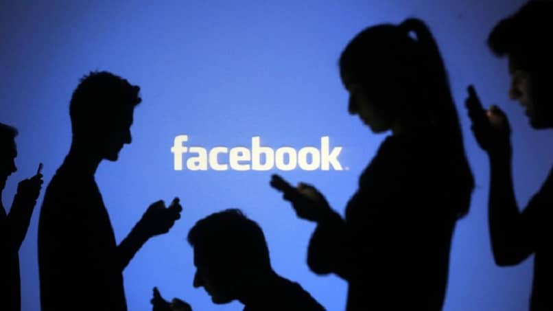 logo facebook con persone e cellulari connessi alla rete