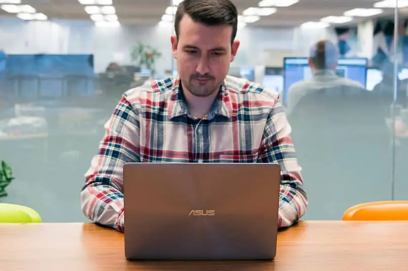 uomo in ufficio con laptop