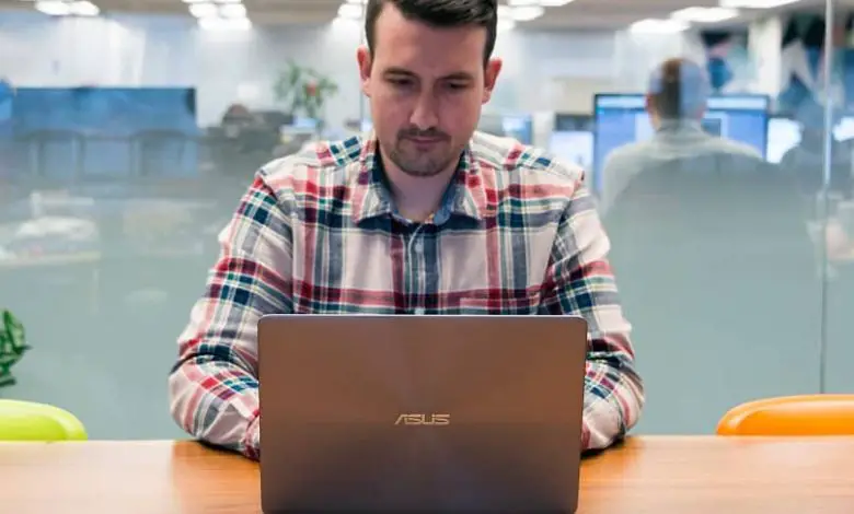 uomo in ufficio con laptop