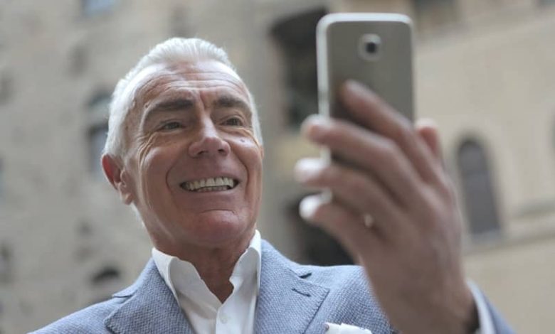 uomo anziano con il cellulare in mano che fa una videochiamata