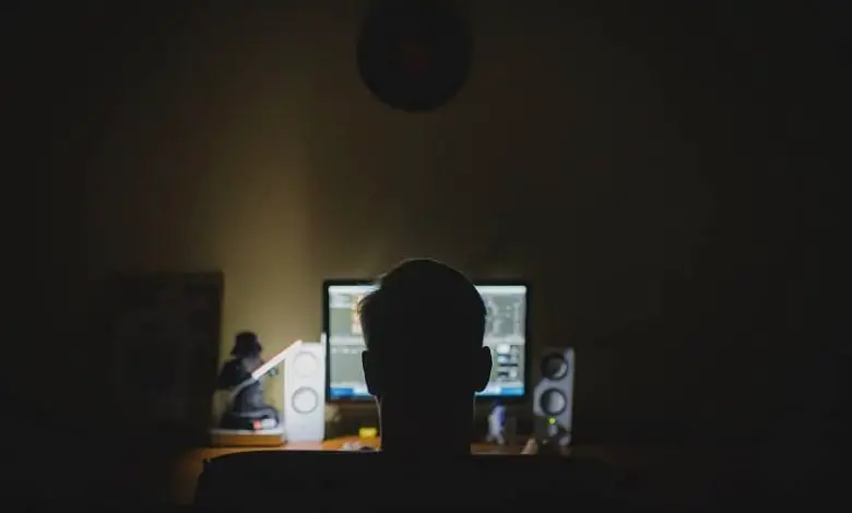 l'uomo guarda la luce del monitor in una stanza buia