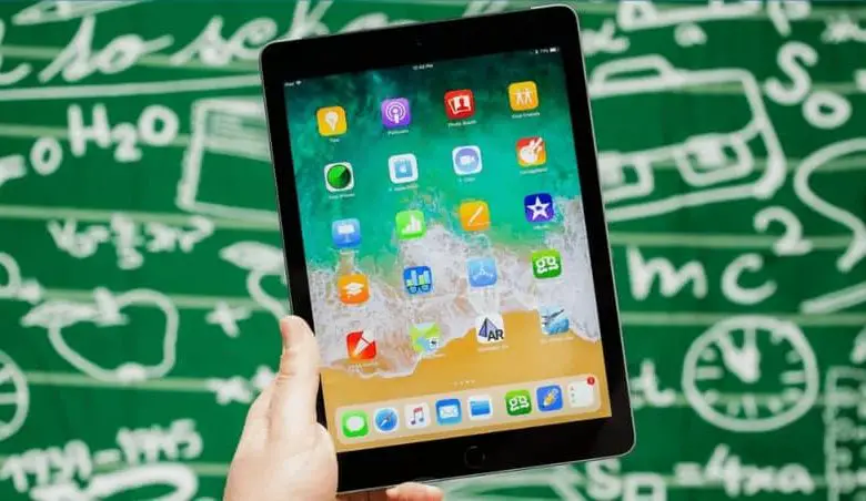 iPad in mano e sfondo di formule matematiche