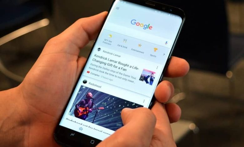 Alcune mani con un telefono nel motore di ricerca di Google