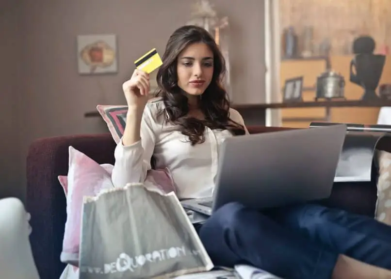 donna con i suoi acquisti e laptop con carta di credito