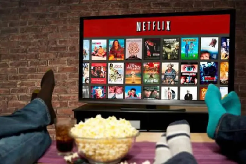 famiglia che guarda Netflix dal divano mangiando popcorn