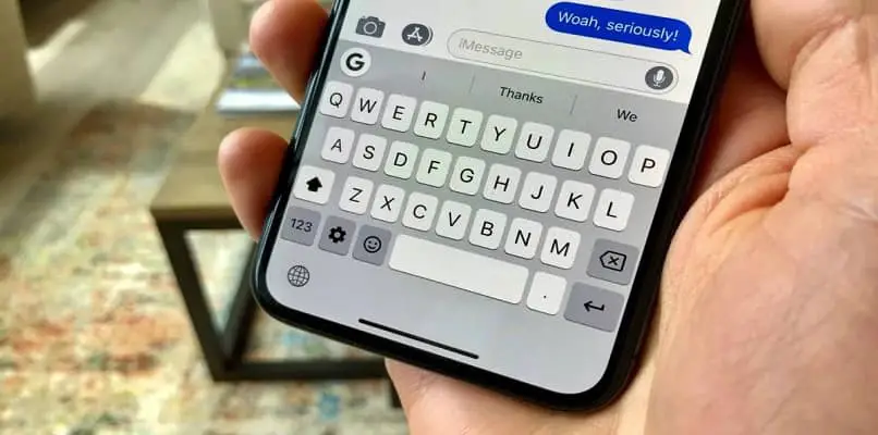 iphone in mano sulla tastiera a schermo