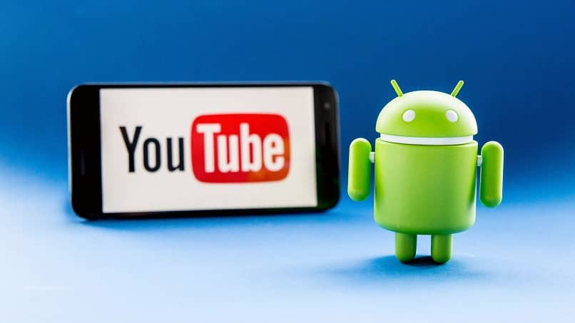 Un cellulare in sottofondo con l'applicazione YouTube con il logo di Android