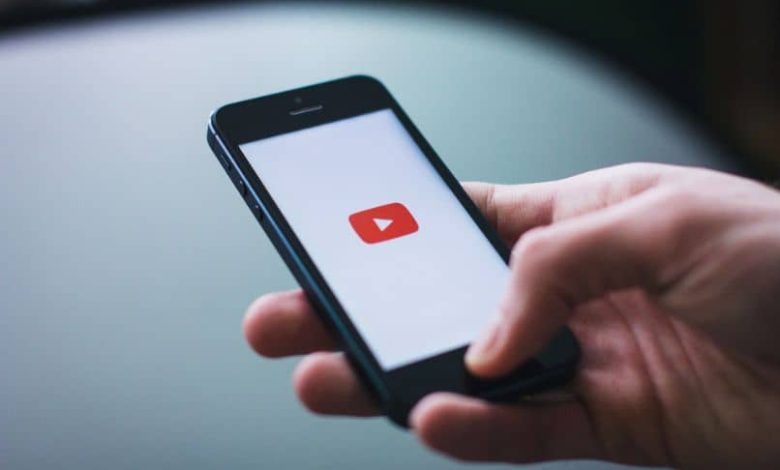 smartphone con logo youtube in mano